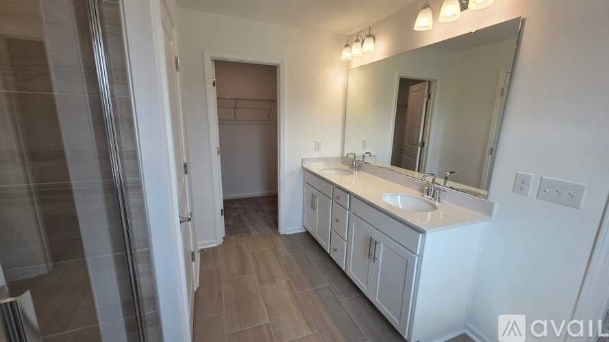 A bathroom with a sink, mirror, and wooden floors.