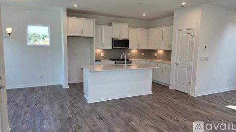 A kitchen with a white island in the middle of the room.