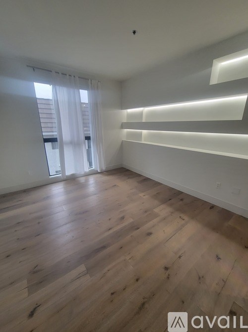 A room with wooden flooring and white walls.
