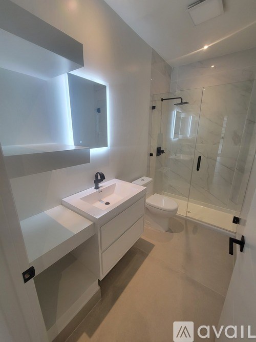 A bathroom with a sink, toilet, and shower.