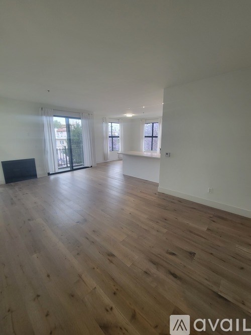 A room with wooden flooring and a large window.