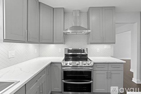 A kitchen with a stove top oven and cabinets.