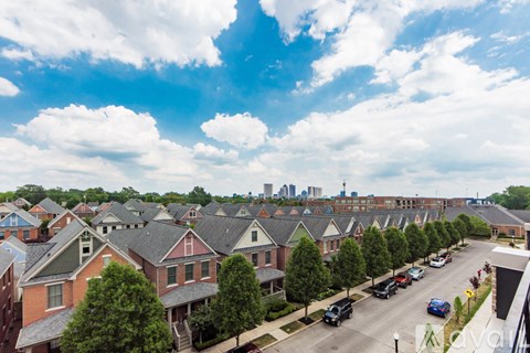 A suburban street with cars parked on the side and houses on both sides.