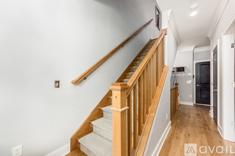 A wooden staircase with a white carpeted landing.