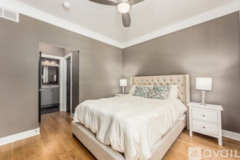A bedroom with a bed, nightstand, and a ceiling fan.