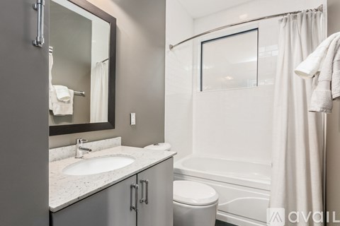 A bathroom with a white toilet, sink, and bathtub.