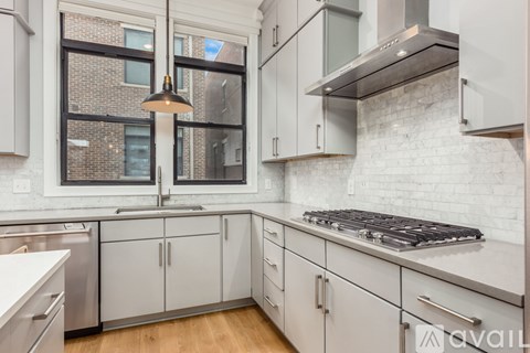 A kitchen with white cabinets and a stove top oven.