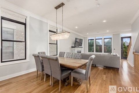A modern dining room with a wooden table and grey chairs.
