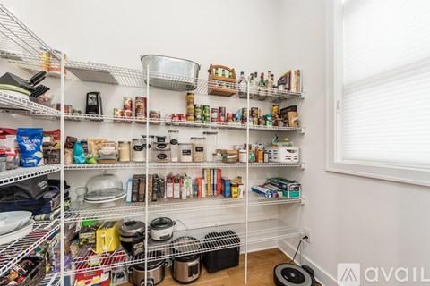 A kitchen pantry with white shelves and organized food items.