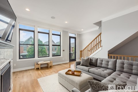 A living room with a grey couch and a wooden coffee table.