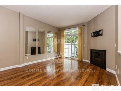 A living room with a fireplace and a television mounted on the wall.