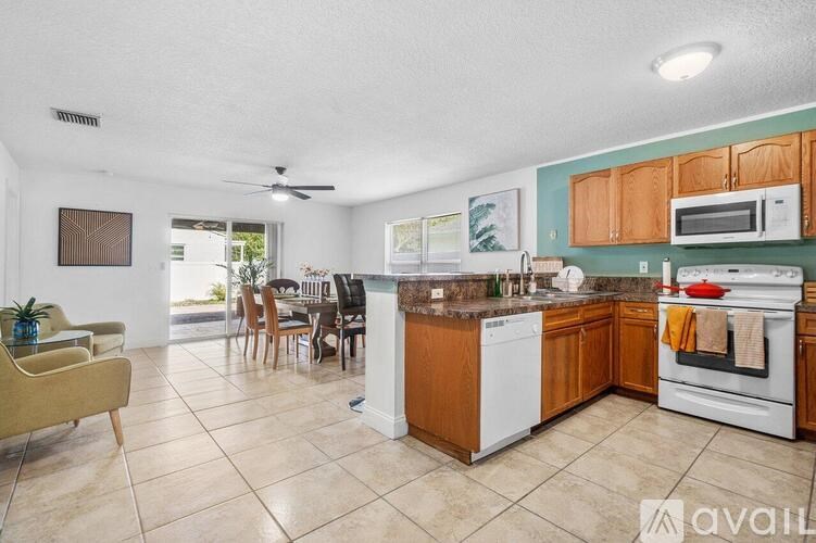 A kitchen with wooden cabinets and a white dishwasher.