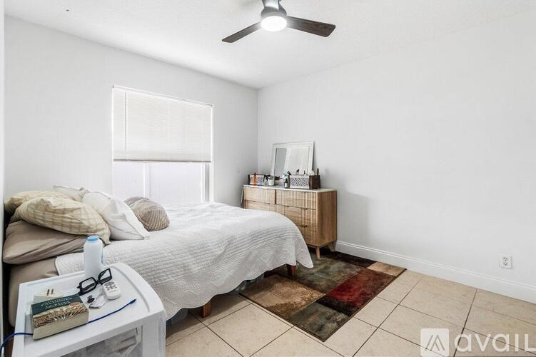 A bedroom with a bed, nightstand, and a ceiling fan.