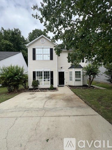 A two-story house with a driveway in front.