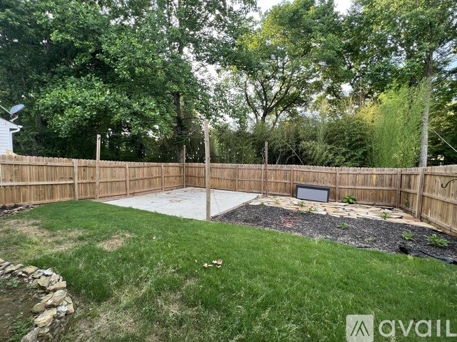 A backyard with a wooden fence and a stone wall.