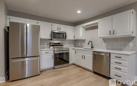 A kitchen with white cabinets and stainless steel appliances.