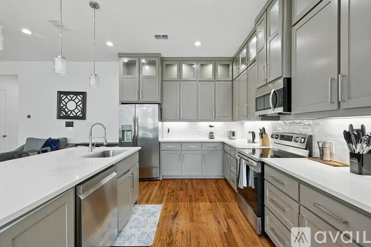 A modern kitchen with stainless steel appliances and wooden floors.