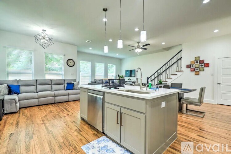 A kitchen with a wooden floor and a stainless steel dishwasher.
