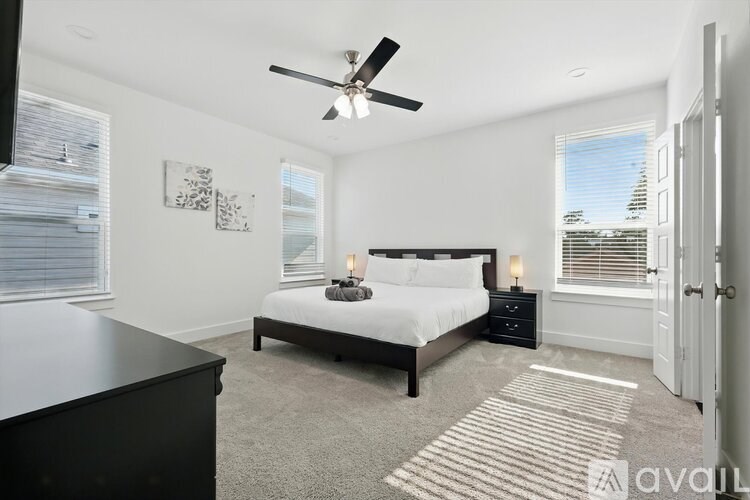A bedroom with a bed, nightstand, and a ceiling fan.