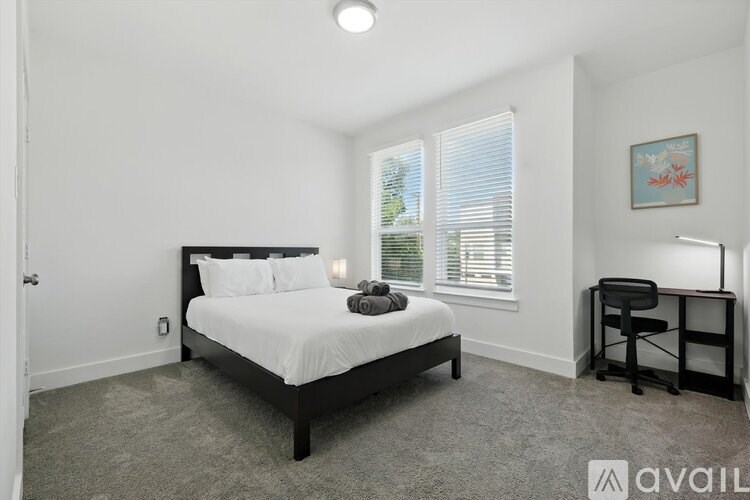 A bedroom with a bed, desk, and chair.