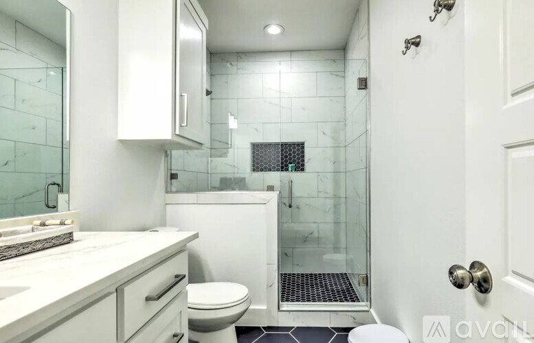 A white bathroom with a walk in shower.
