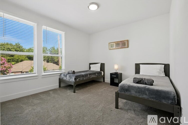 A bedroom with two beds and a window showing an outdoor view.