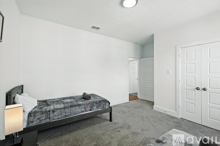 A bedroom with a bed, a nightstand, and a wardrobe.