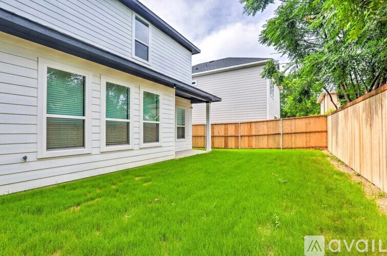 A house with a fence and a green lawn.