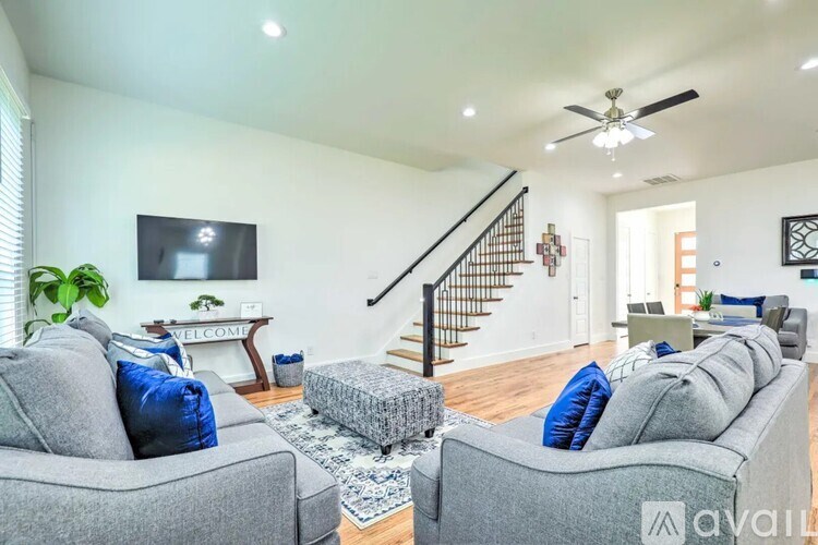 A living room with grey couches and a staircase.
