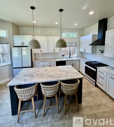A kitchen with a marble table and wicker chairs.