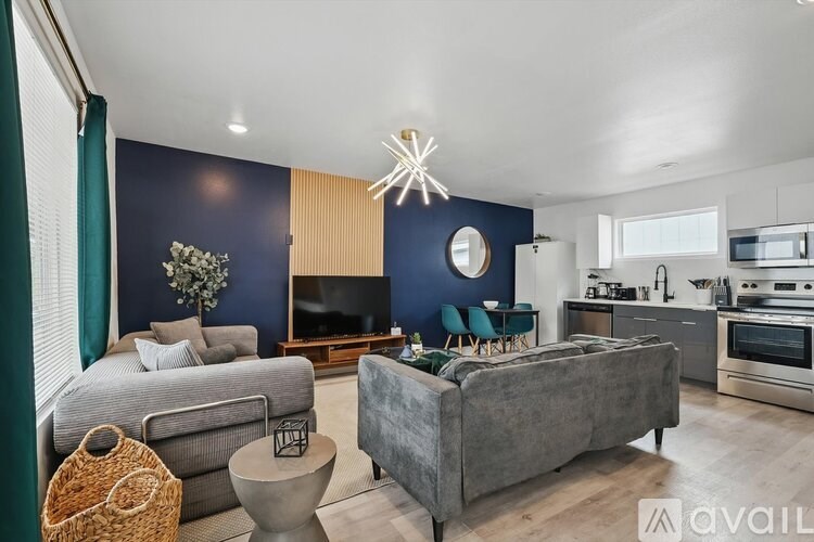 A modern living room with a grey couch and a grey sofa.