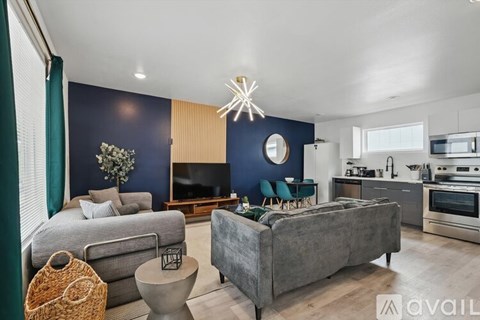 A modern living room with a grey couch and a grey sofa.
