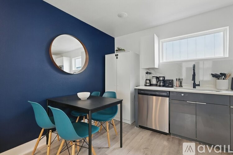 A kitchen with blue walls and a round mirror on the wall.