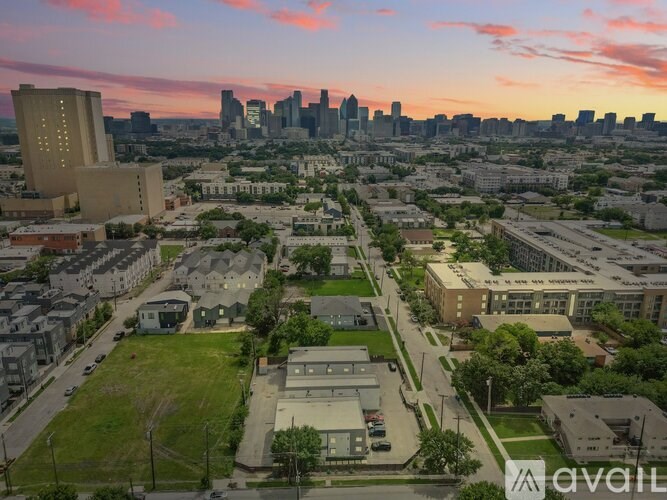A cityscape with buildings and a sunset in the background.