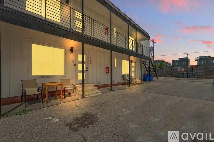 A building with a balcony and a table and chairs outside.