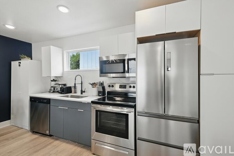 A modern kitchen with stainless steel appliances and white cabinets.