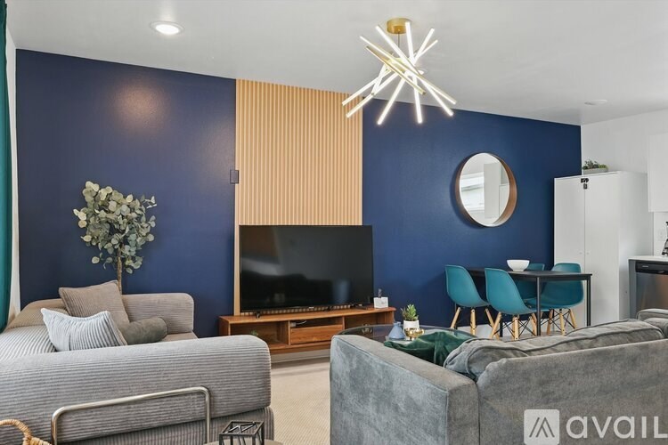 A living room with a grey sofa, a grey armchair, a grey couch, a grey chair, a grey couch, a grey couch, a grey couch, a grey couch, a grey couch, a