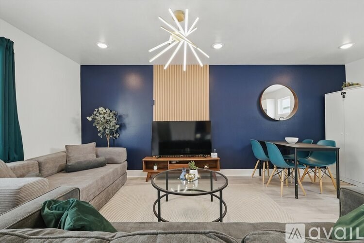 A living room with a grey sofa, a coffee table, and a television.
