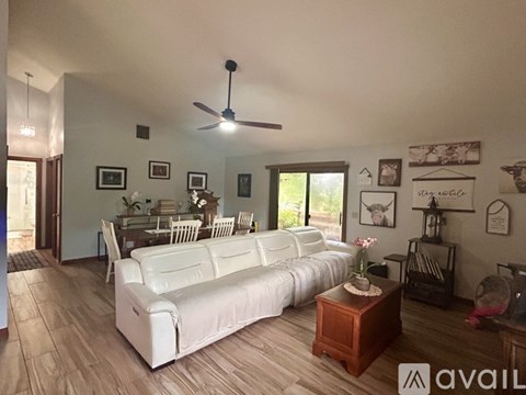 A living room with a white couch and a ceiling fan.
