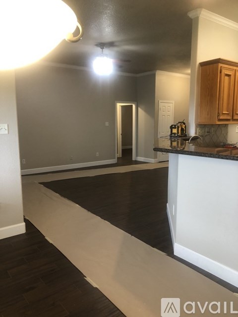A kitchen with a counter top and wooden cabinets.