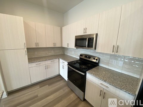 A kitchen with white cabinets and a granite countertop.
