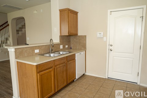 A kitchen with wooden cabinets and a white door.
