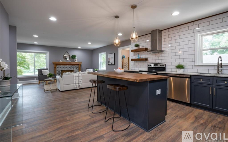 A modern kitchen with dark wood floors and a central island.