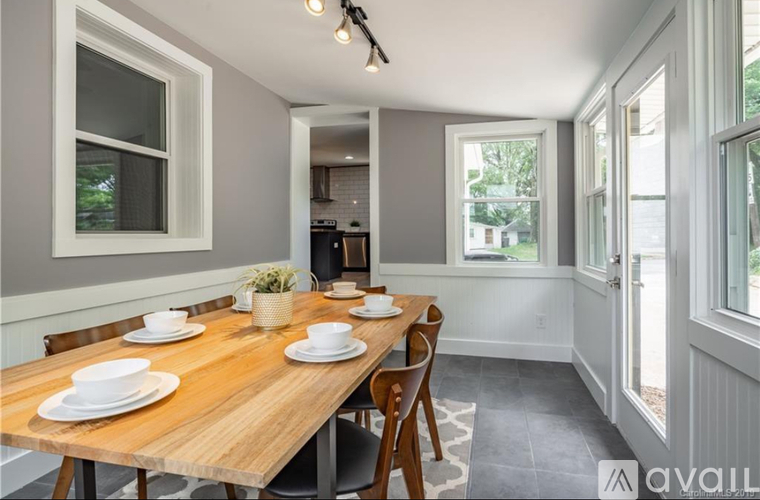 A dining room with a wooden table set for two.