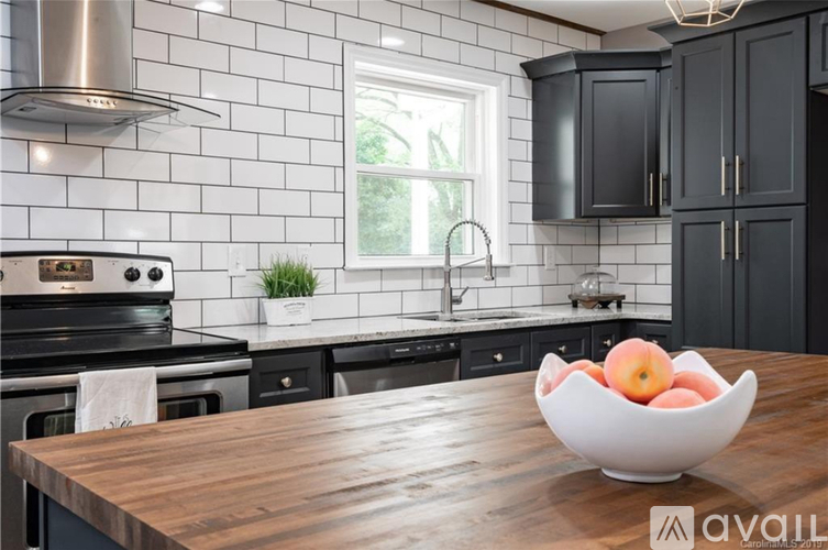 A kitchen with a wooden table and a bowl of fruit on it.