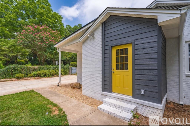 A house with a yellow door and a grey exterior.