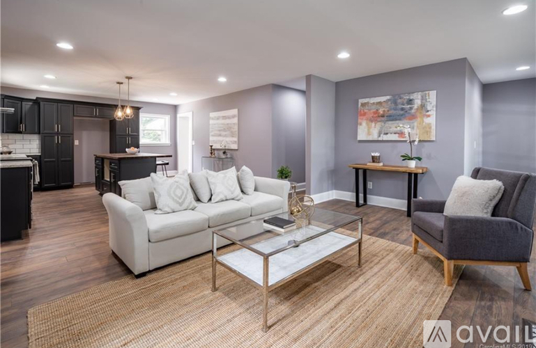 A modern living room with a white sofa and a glass coffee table.