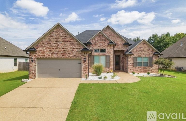 A brick house with a garage and a driveway.