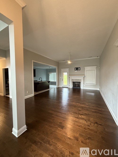A spacious room with wooden floors and white walls.