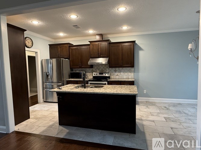 A kitchen with a granite countertop and wooden cabinets.